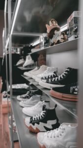 A collection of trendy sneakers on metal shelves in a modern store setting.